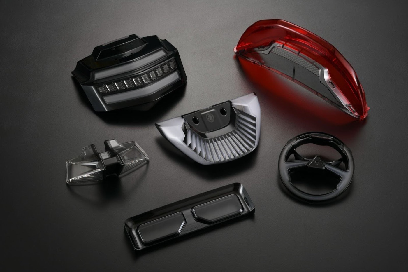 LongTeam two-shot and precision molded automotive components arranged on a dark surface